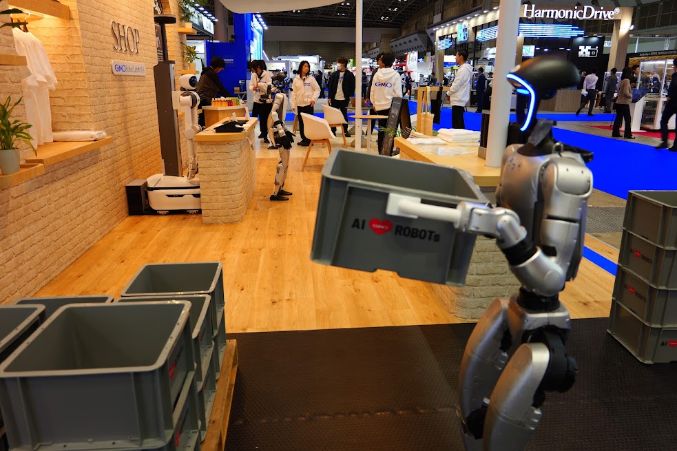 Unitree G1が展示会で荷物を持ち上げている画像。